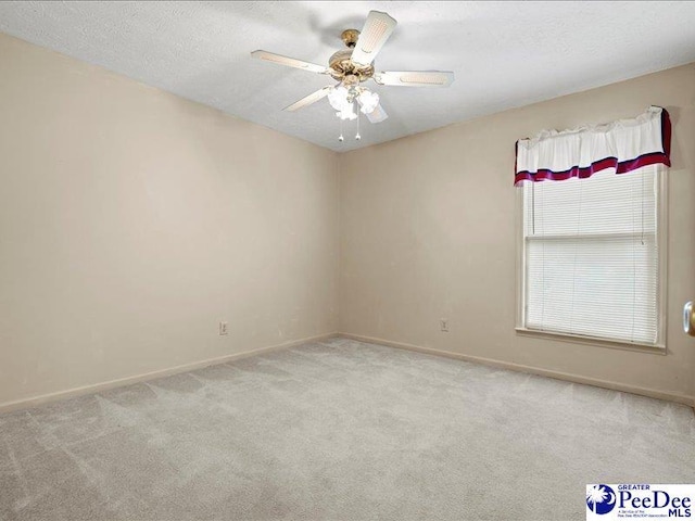 carpeted spare room with ceiling fan and a textured ceiling