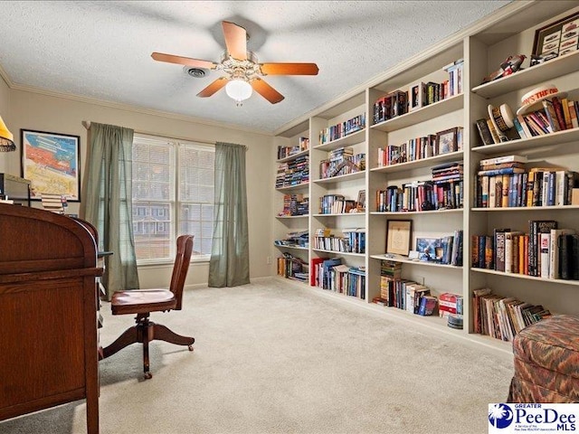 sitting room with ceiling fan, ornamental molding, carpet flooring, and a textured ceiling