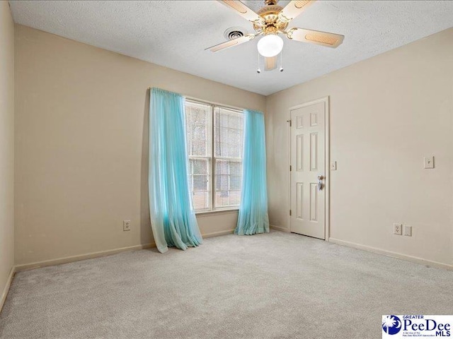 carpeted empty room featuring ceiling fan and a textured ceiling