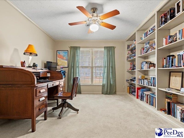 carpeted home office featuring ceiling fan, ornamental molding, and a textured ceiling