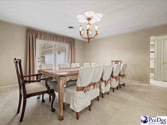 carpeted dining room featuring ornamental molding, a textured ceiling, and a notable chandelier