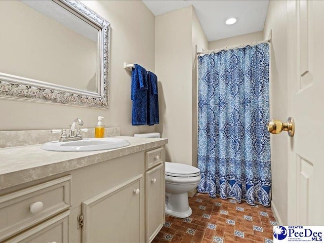 bathroom with vanity, curtained shower, and toilet