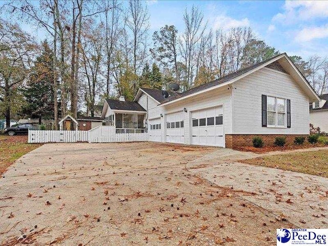 view of side of home featuring a garage and a sunroom