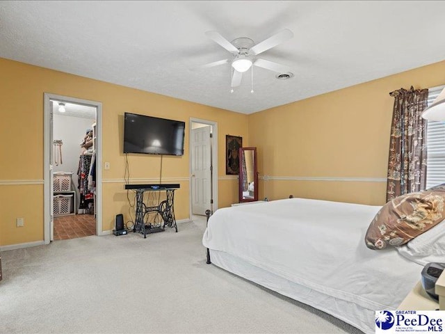 carpeted bedroom featuring a spacious closet, ceiling fan, and a closet