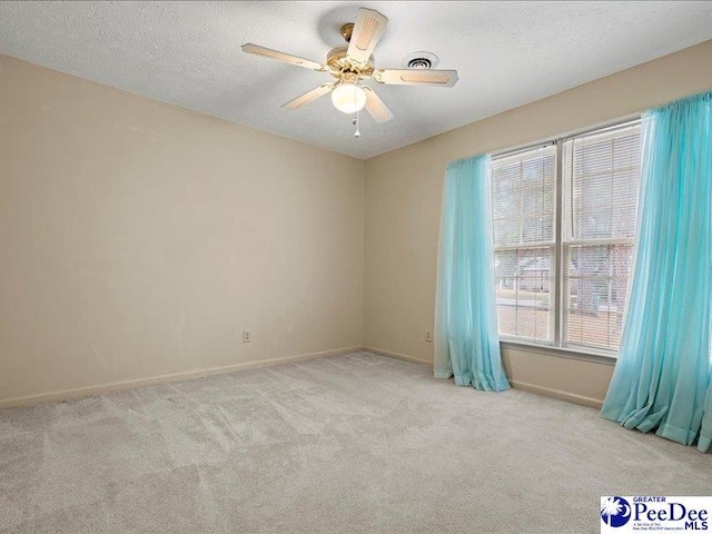 carpeted spare room featuring ceiling fan and a textured ceiling