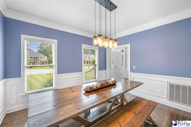 912 Ivanhoe Dr, Florence, SC 29505 - dining area with a textured ceiling, wainscoting, a chandelier, crown molding, and wood finished floors