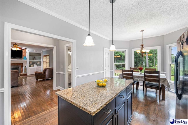 912 Ivanhoe Dr, Florence, SC 29505 - kitchen with a textured ceiling, dark wood-type flooring, a fireplace, a chandelier, and ceiling fan