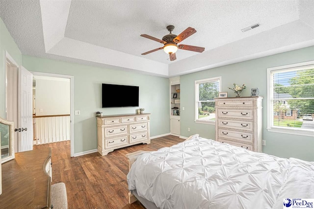 912 Ivanhoe Dr, Florence, SC 29505 - bedroom featuring a tray ceiling, wood finished floors, a textured ceiling, and a ceiling fan