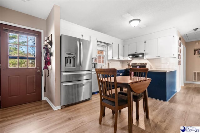 kitchen featuring light wood-type flooring, under cabinet range hood, light countertops, and stainless steel refrigerator with ice dispenser