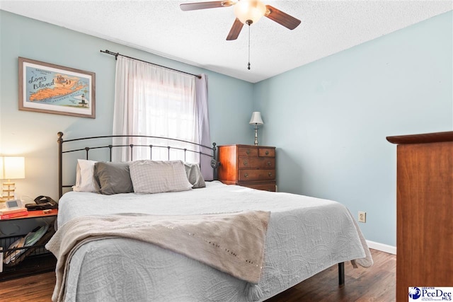 bedroom featuring a ceiling fan, a textured ceiling, baseboards, and wood finished floors