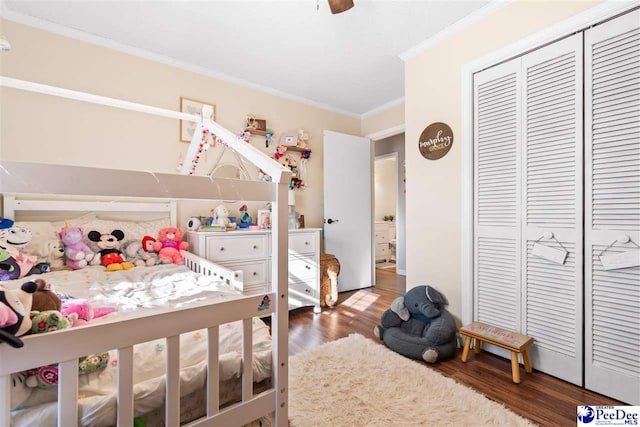 bedroom with a ceiling fan, a closet, crown molding, and wood finished floors