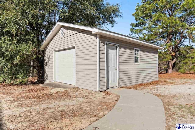 view of outdoor structure featuring driveway and an outbuilding