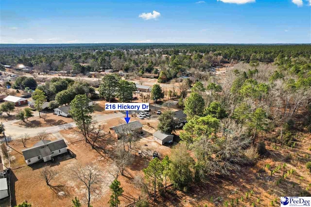 birds eye view of property featuring a forest view