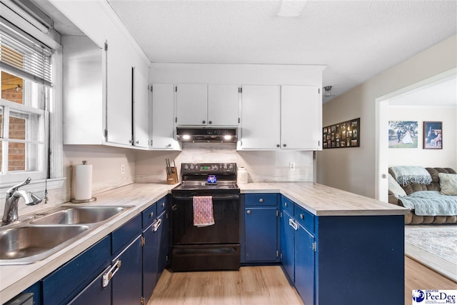 kitchen featuring a peninsula, blue cabinetry, under cabinet range hood, black range with electric cooktop, and a sink