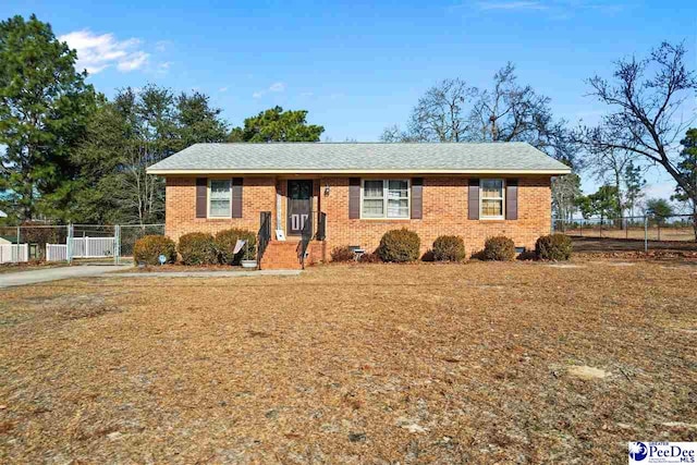 ranch-style home with a gate, fence, and brick siding