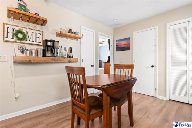 dining space with baseboards and light wood-style floors