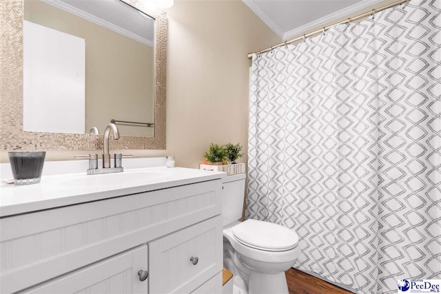 bathroom featuring wood finished floors, vanity, toilet, and crown molding