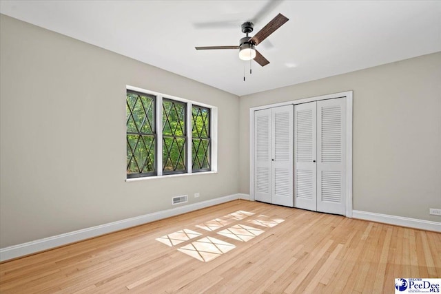 unfurnished bedroom featuring ceiling fan, light hardwood / wood-style floors, and a closet