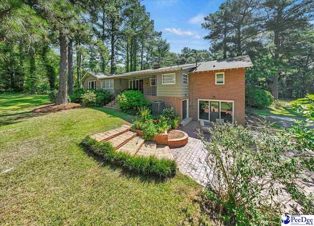 back of house with central AC, a patio area, and a lawn