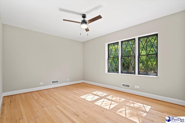 empty room with ceiling fan and light hardwood / wood-style floors