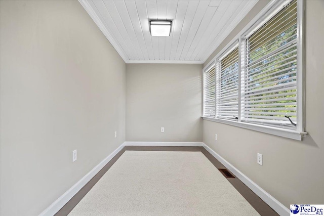 empty room with wood ceiling and crown molding