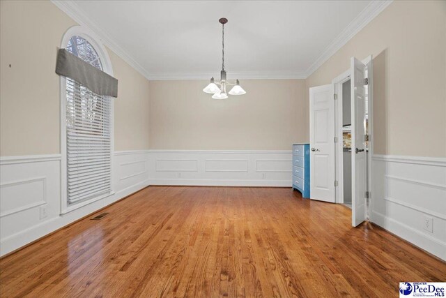 3406 Sussex Ct, Florence, SC 29501 - unfurnished dining area featuring a notable chandelier, ornamental molding, and hardwood / wood-style floors