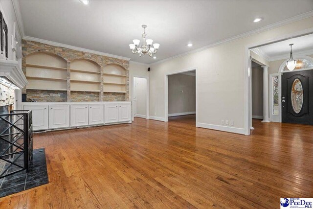 3406 Sussex Ct, Florence, SC 29501 - unfurnished living room with wood-type flooring, crown molding, a chandelier, and built in shelves