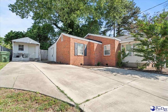 907 Adams Ave, Florence, SC 29501 - rear view of property with concrete driveway, brick siding, crawl space, and fence