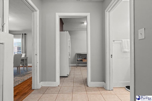 907 Adams Ave, Florence, SC 29501 - hallway with baseboards, light tile patterned flooring, and a textured ceiling