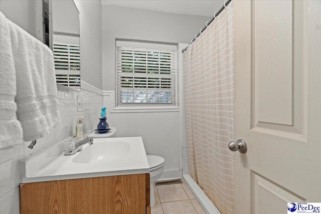 907 Adams Ave, Florence, SC 29501 - full bathroom with toilet, tile patterned floors, tile walls, wainscoting, and vanity