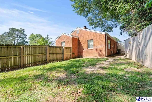 907 Adams Ave, Florence, SC 29501 - back of house featuring a fenced backyard, brick siding, and a lawn