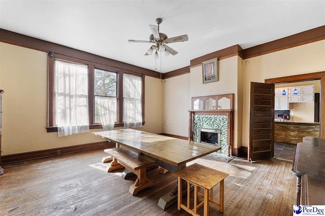 dining area featuring hardwood / wood-style flooring, a fireplace, and ceiling fan