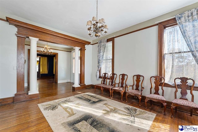 living area with a notable chandelier and decorative columns