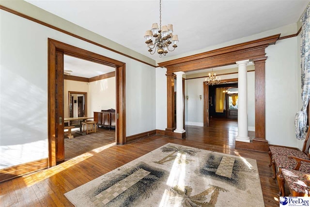 interior space with decorative columns, dark hardwood / wood-style floors, and a notable chandelier