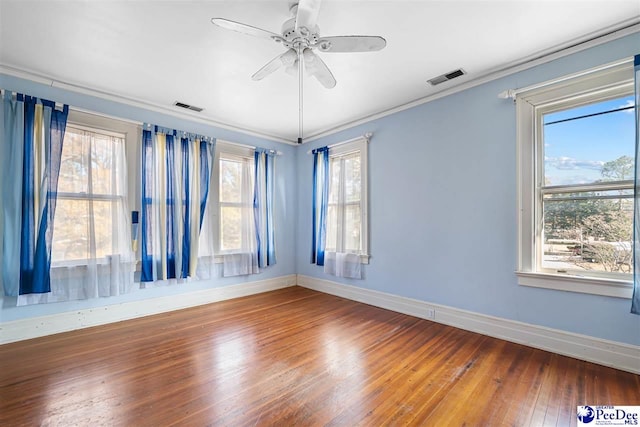 unfurnished room featuring crown molding, ceiling fan, plenty of natural light, and wood-type flooring