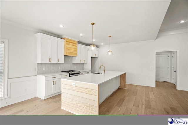 4064 Crest Cv, Florence, SC 29501 - kitchen featuring a kitchen island with sink, a sink, white cabinetry, light countertops, and stainless steel gas range