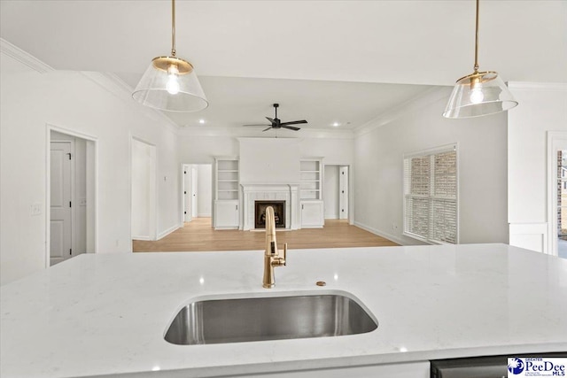 4064 Crest Cv, Florence, SC 29501 - kitchen featuring hanging light fixtures, light stone counters, a sink, and ornamental molding