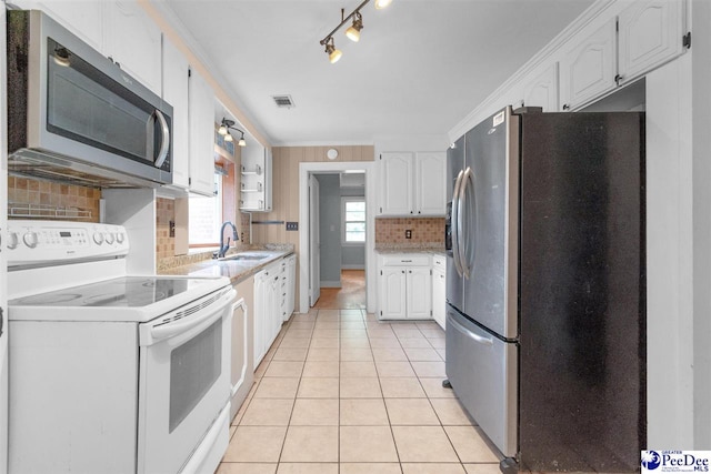 23 Mcrae Rd, Cheraw, SC 29520 - kitchen with stainless steel appliances, white cabinets, decorative backsplash, light tile patterned floors, and ornamental molding