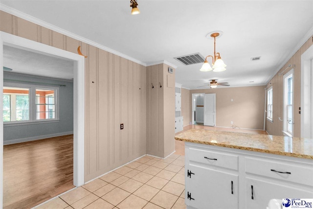 23 Mcrae Rd, Cheraw, SC 29520 - kitchen with plenty of natural light, crown molding, white cabinetry, light stone countertops, and hanging light fixtures