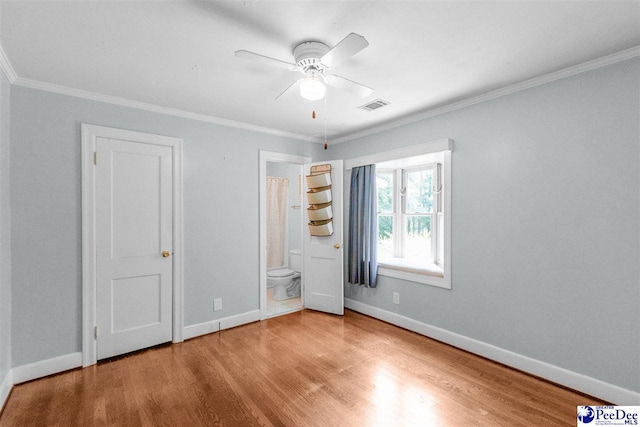 23 Mcrae Rd, Cheraw, SC 29520 - unfurnished bedroom with wood finished floors, crown molding, connected bathroom, and a ceiling fan