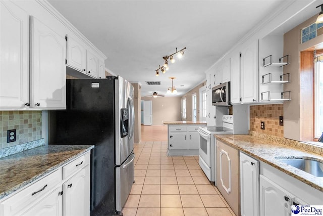 23 Mcrae Rd, Cheraw, SC 29520 - kitchen featuring stainless steel appliances, white cabinets, light tile patterned floors, ceiling fan, and a peninsula