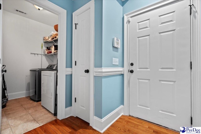 laundry area featuring light wood finished floors, visible vents, baseboards, laundry area, and separate washer and dryer