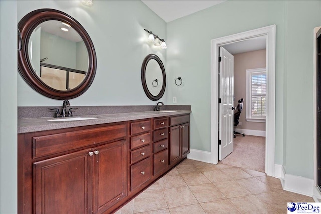 full bathroom with tile patterned flooring, double vanity, baseboards, and a sink