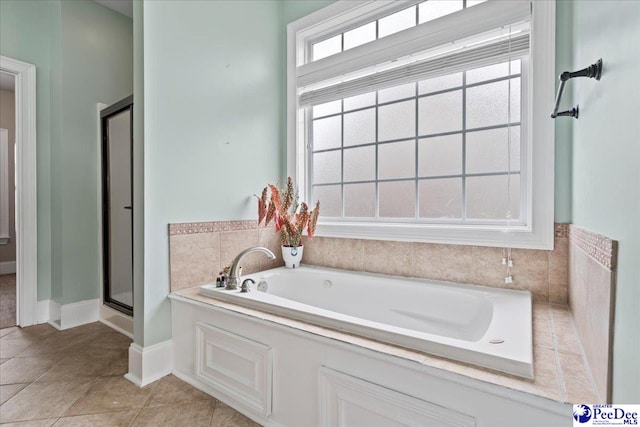 full bathroom featuring a stall shower, a bath, and tile patterned floors