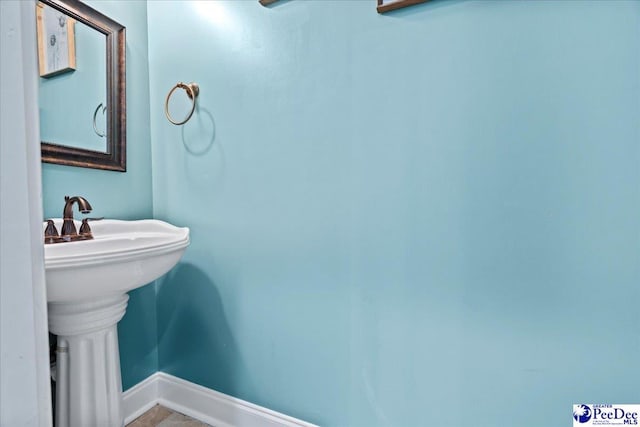 bathroom featuring baseboards and a sink