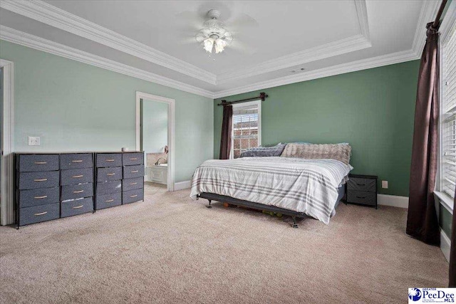 bedroom featuring baseboards, a tray ceiling, light carpet, crown molding, and connected bathroom