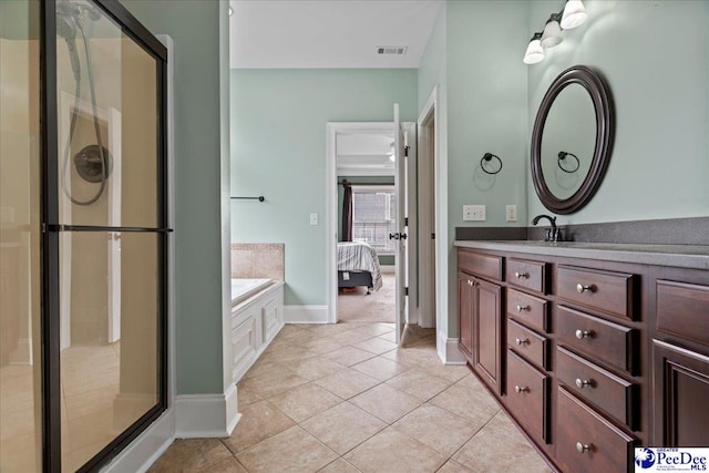 ensuite bathroom with tile patterned floors, a stall shower, vanity, and a garden tub