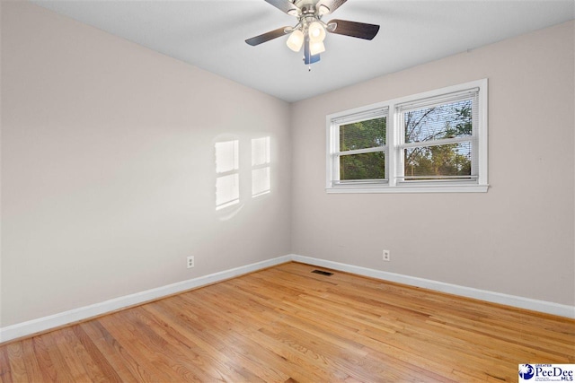 empty room featuring light wood-style flooring, baseboards, and visible vents