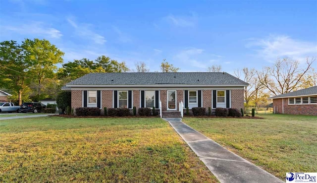 view of front of home with brick siding and a front lawn