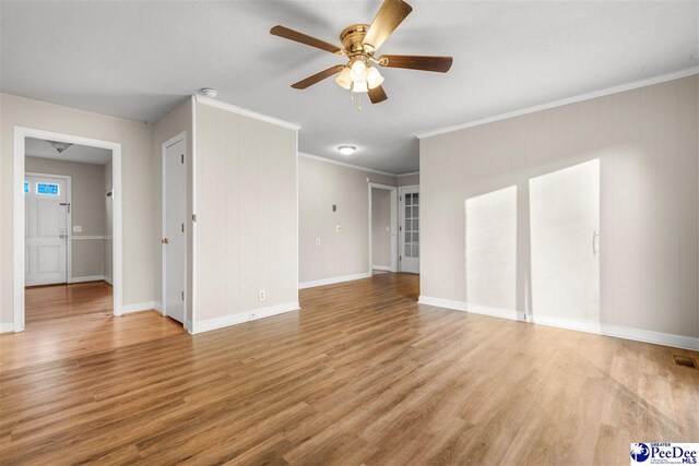 unfurnished living room featuring light wood-style flooring, crown molding, baseboards, and a ceiling fan